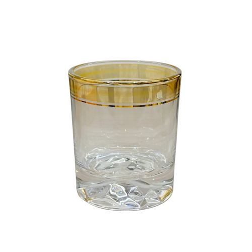 Clear glass tumbler with gold rim on a white background